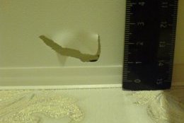 Небольшой разрыв полотна натяжного потолка вблизи стены, который можно обрезать